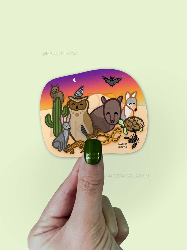 Sticker featuring desert animals: javelina, bobcat, owl, quail, jackrabbit, gila monster, roadrunner, tortoise, coyote, bat, scorpion, snake. Sunset background with a cactus.