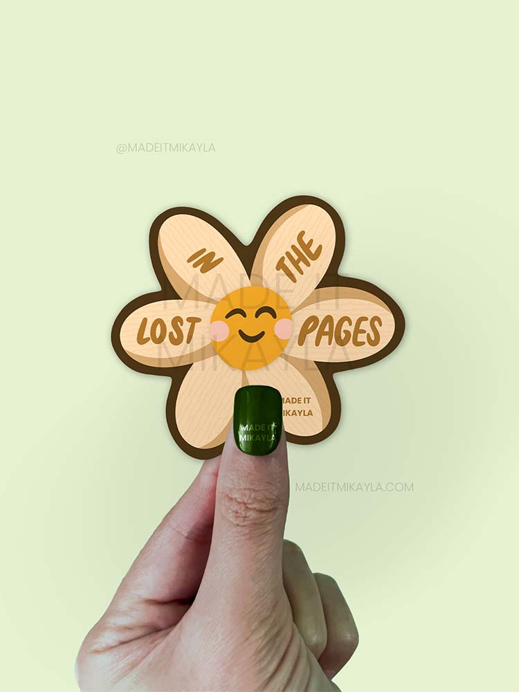 Sticker featuring a cute flower with page texture, with text 'lost in the pages' on the petals.
